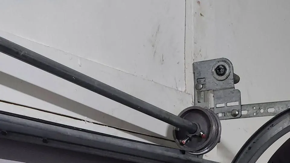 Garage door cable drum on the torsion shaft next to the end bearing plate