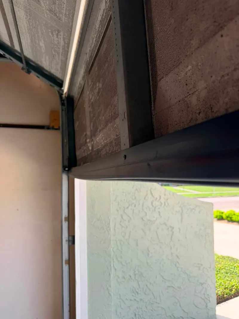 View from inside a garage of a door's top section, the track curve and the header